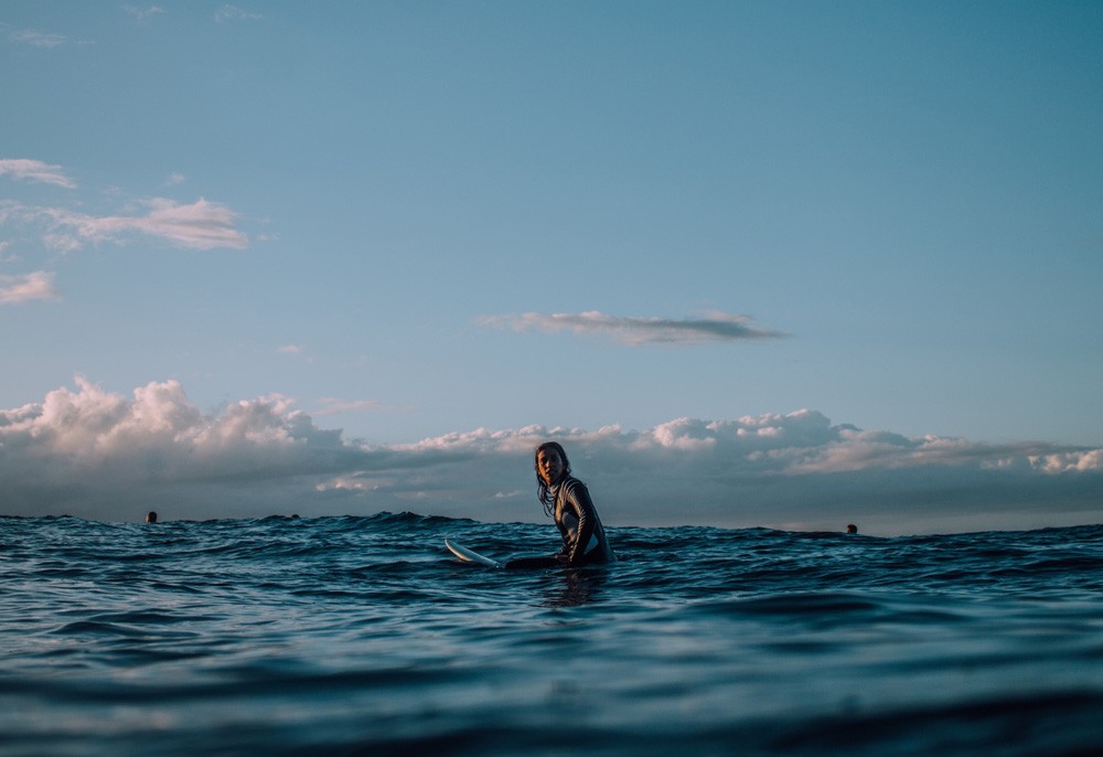 chico de espaldas en una tabla de surf